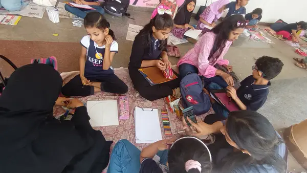 Learners and parents drawing together on floor mats