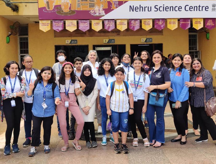 A group of learners and adults on an outing outside the Nehru Science Centre