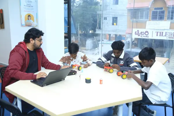 Learners and a mentor testing small robot cars at a Learning Garage