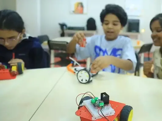 Learners test their robot cars across a Learning Garage table