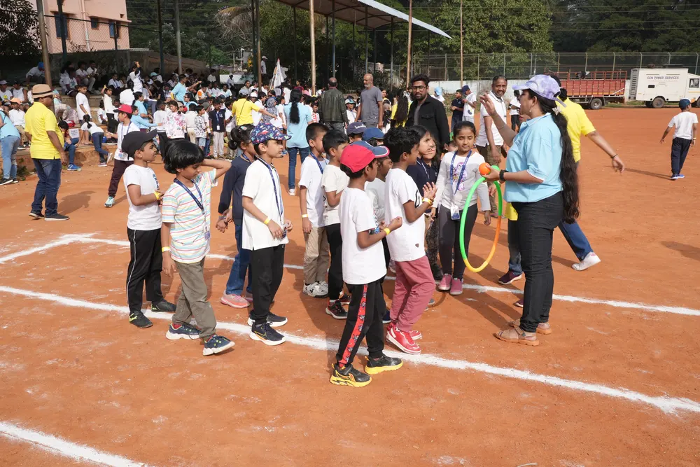 Learners queue with hoops for a Sports Day activity led by a facilitator