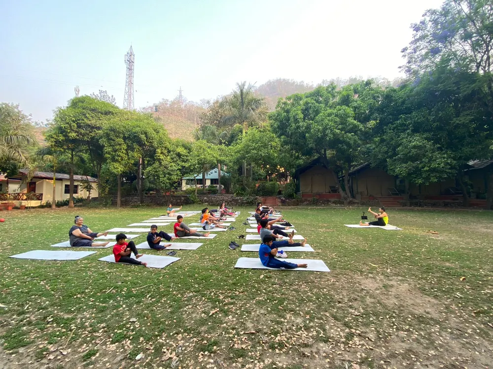 Learners doing yoga on a lawn on the Rishikesh trip