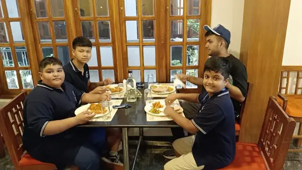 Four learners sharing a meal at a restaurant table on the trip