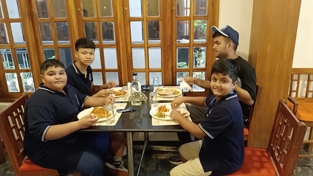 Four learners sharing a meal at a restaurant table on the trip