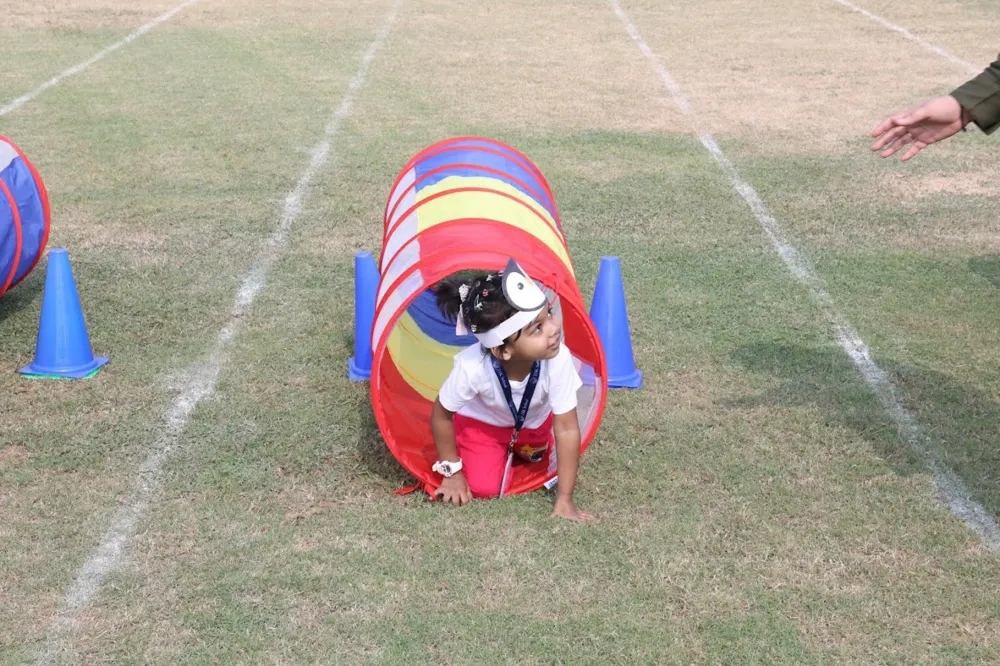 A young learner crawling through a play tunnel at a 21K School Sports Day