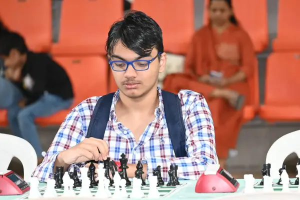 A teenage learner concentrating at a chessboard during a tournament