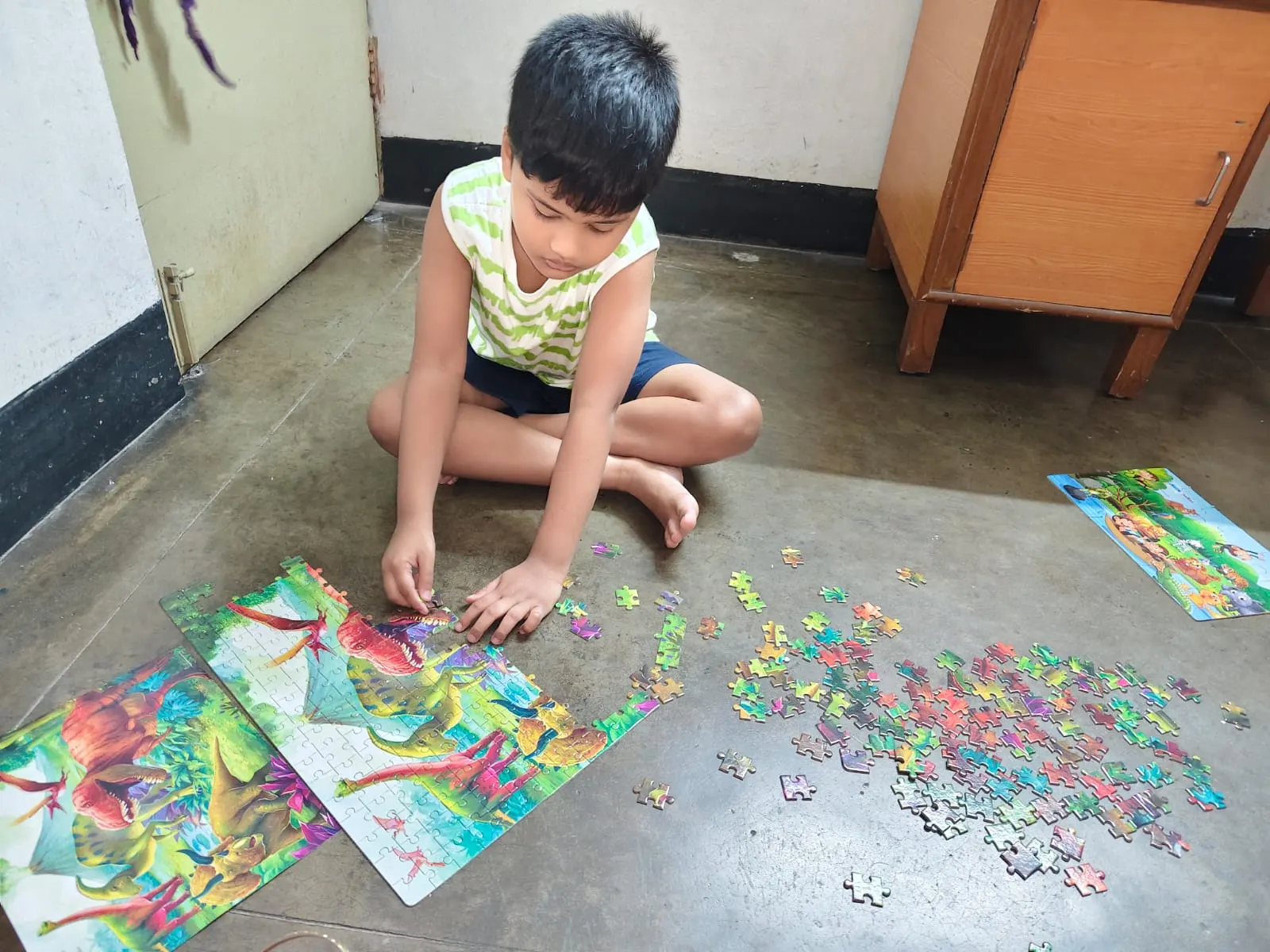 A child putting together a jigsaw puzzle on the floor at home