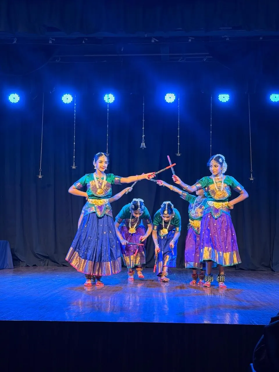 Young dancers performing a classical dance on a lit stage