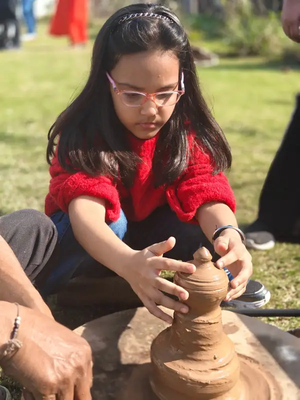 A learner shaping clay on a potter’s wheel