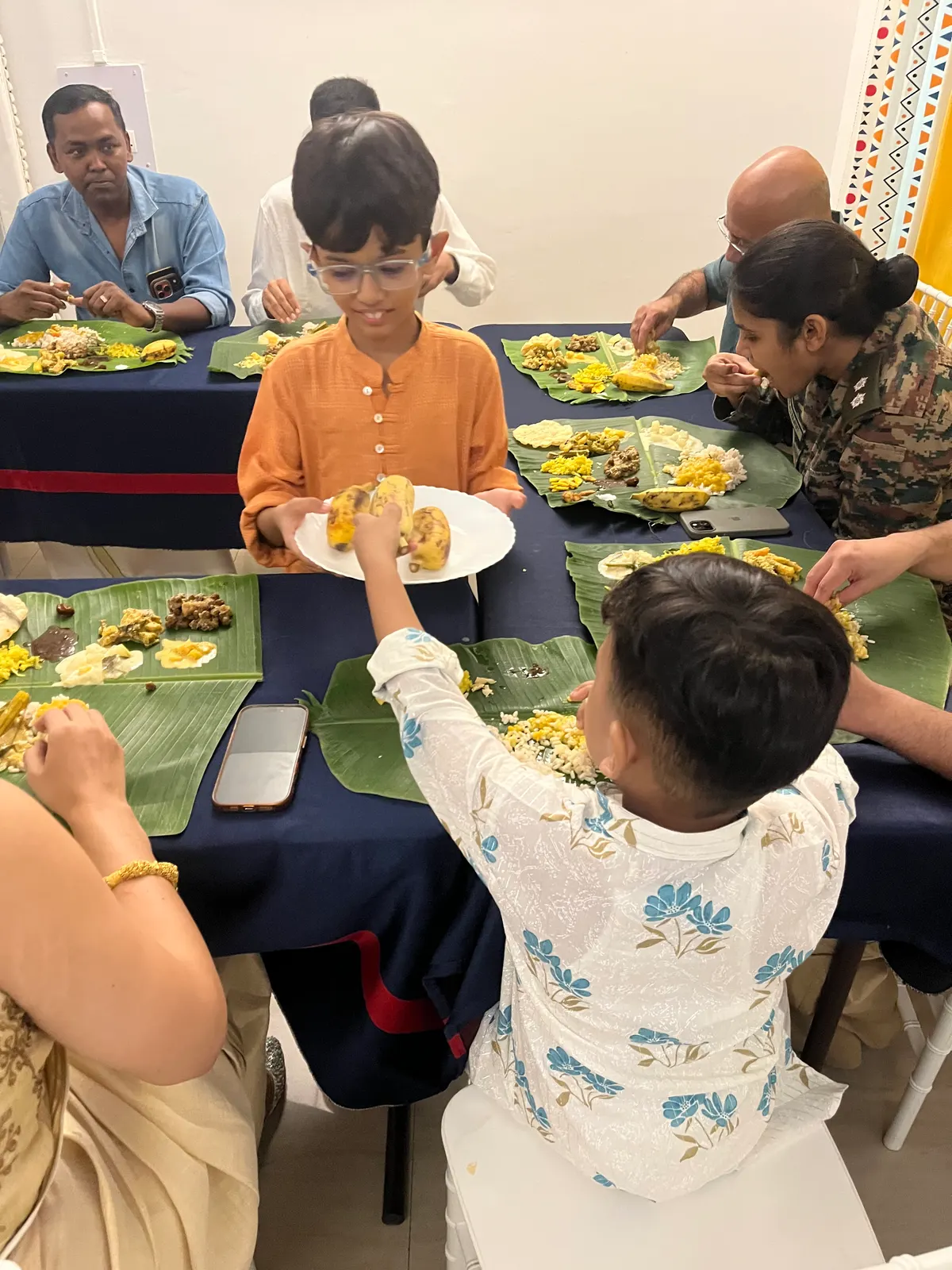 A family sharing a festival meal served on banana leaves at home