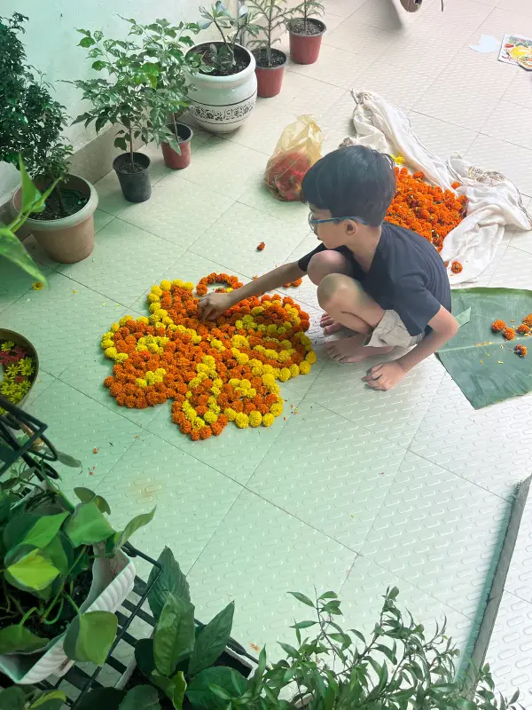 A learner arranging marigold petals into a rangoli