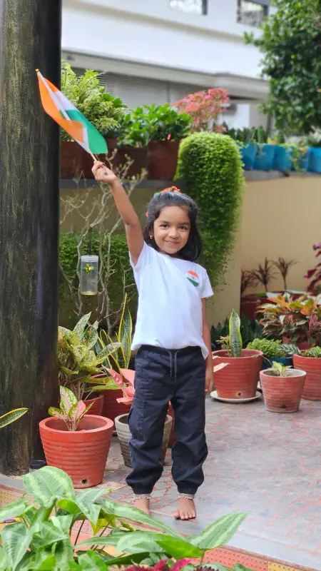 A learner waving a small Indian flag in the garden