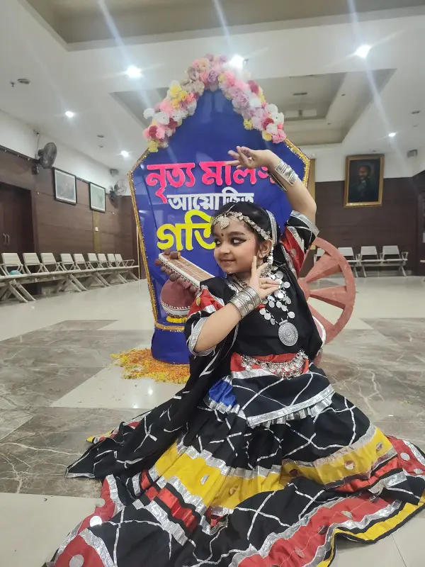 A learner in a folk dance costume performing on stage