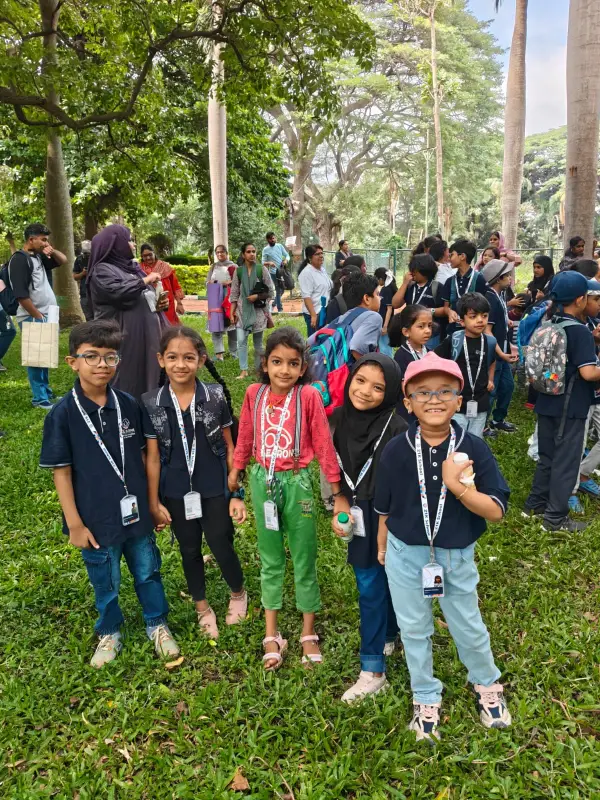 A group of learners in 21K School polos and lanyards on a field trip in a park