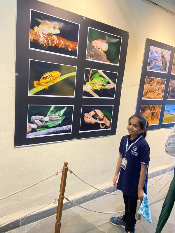 A learner in a 21K School polo at a wildlife photography exhibition