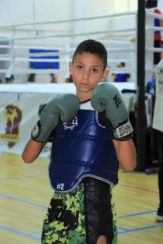 A learner in boxing gloves and a chest guard
