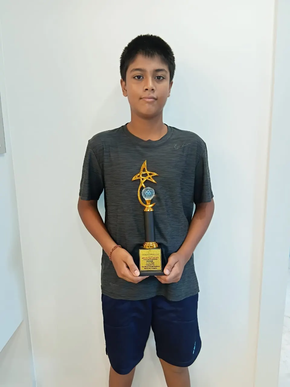 A learner holding his trophy