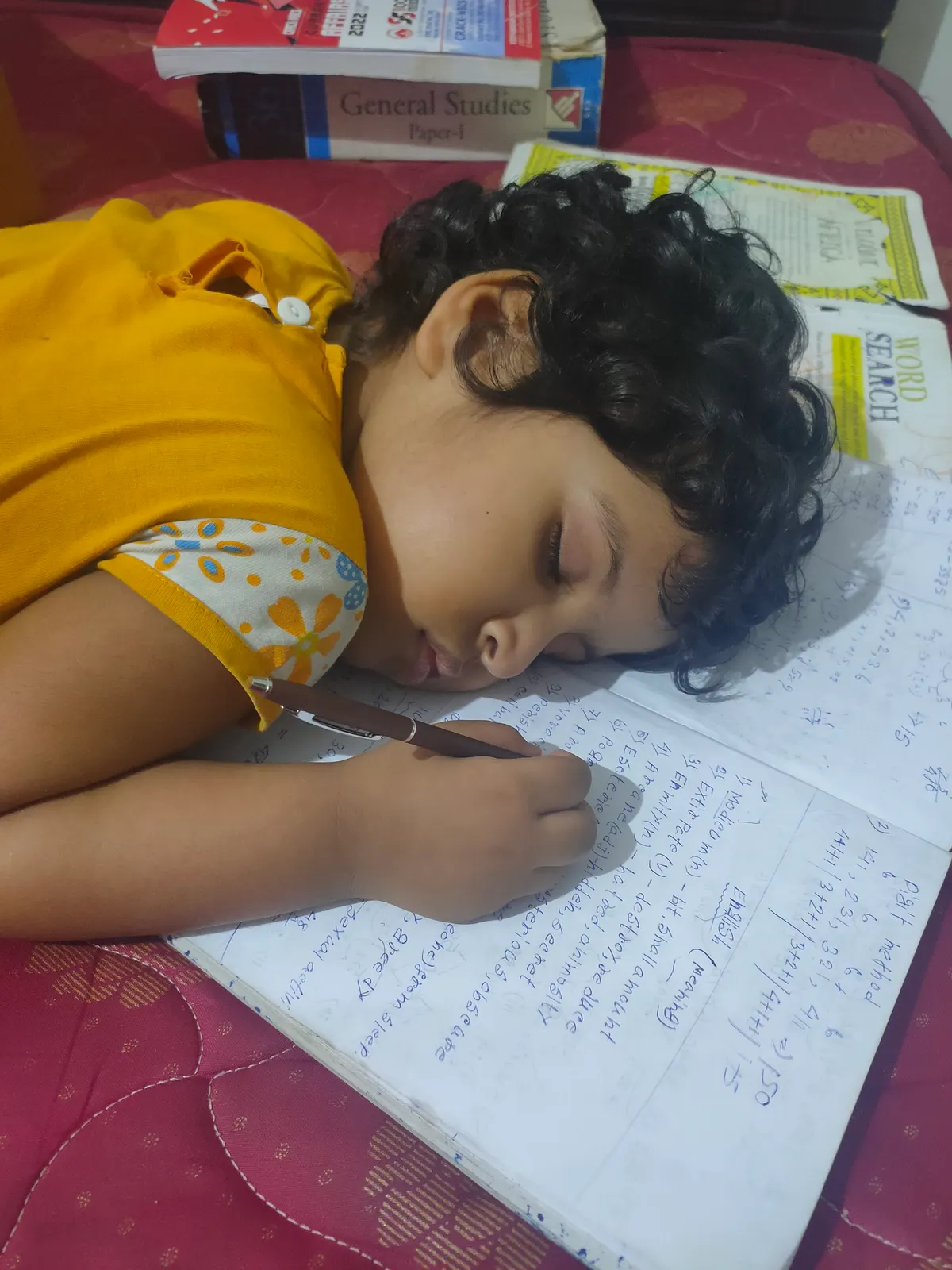 A young learner writing carefully in a notebook at home