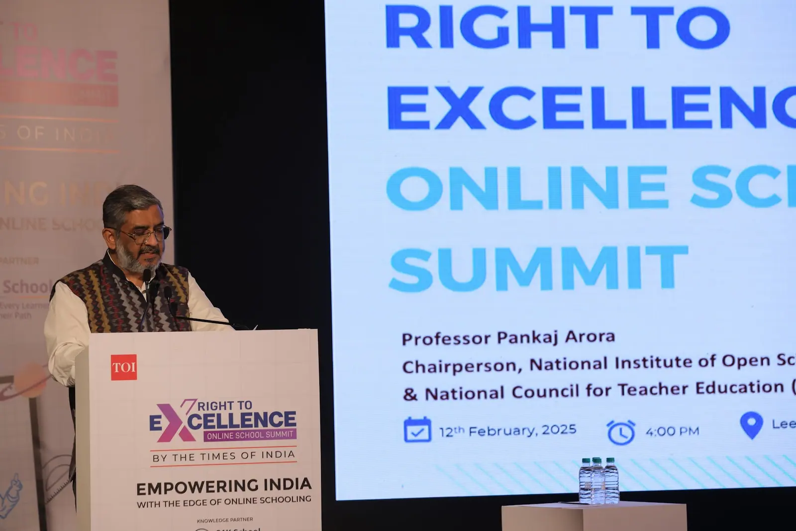 Professor Pankaj Arora gives the keynote at the podium, his name on the screen behind him