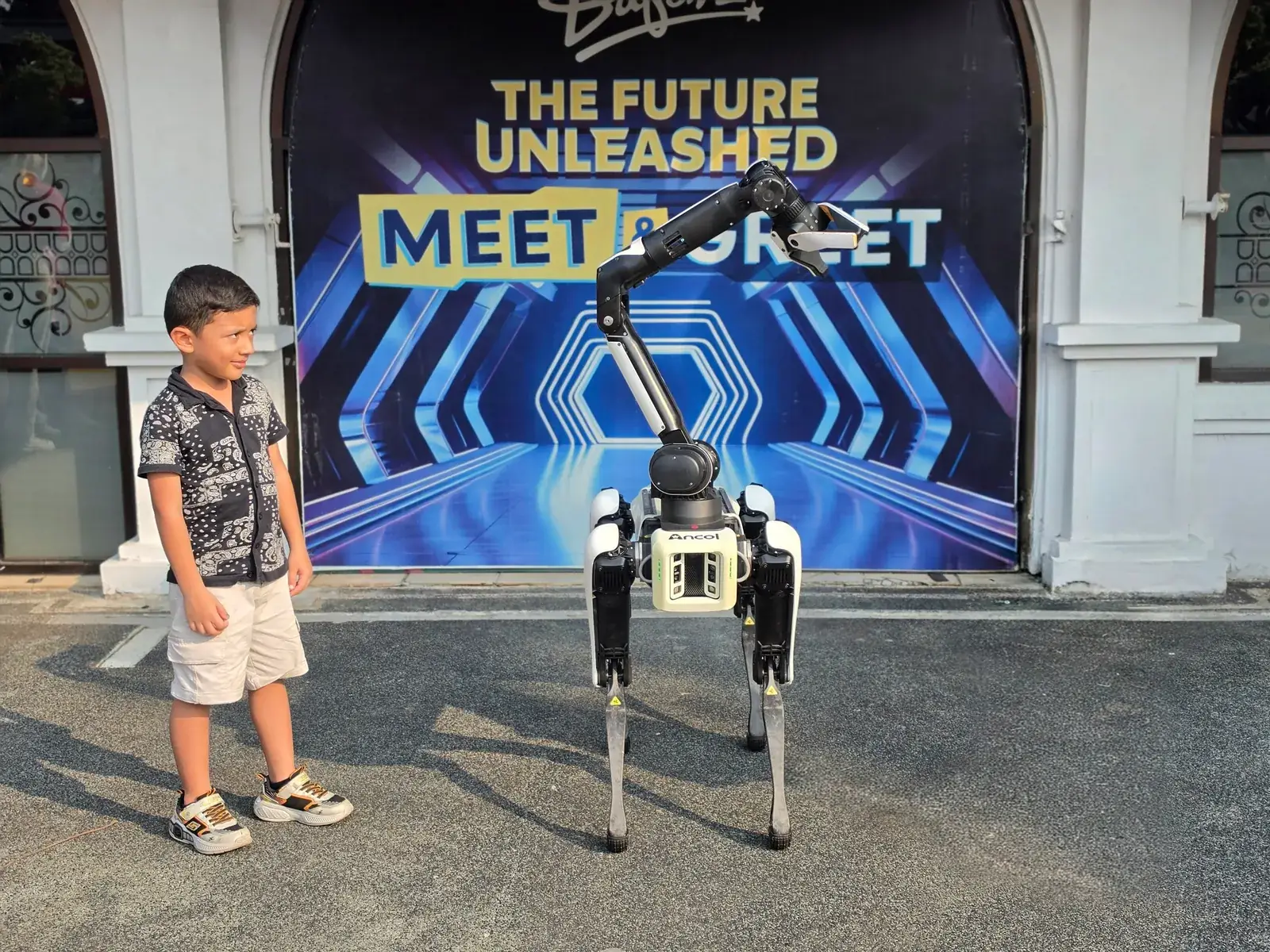 A young learner standing beside a robot dog at a technology exhibition