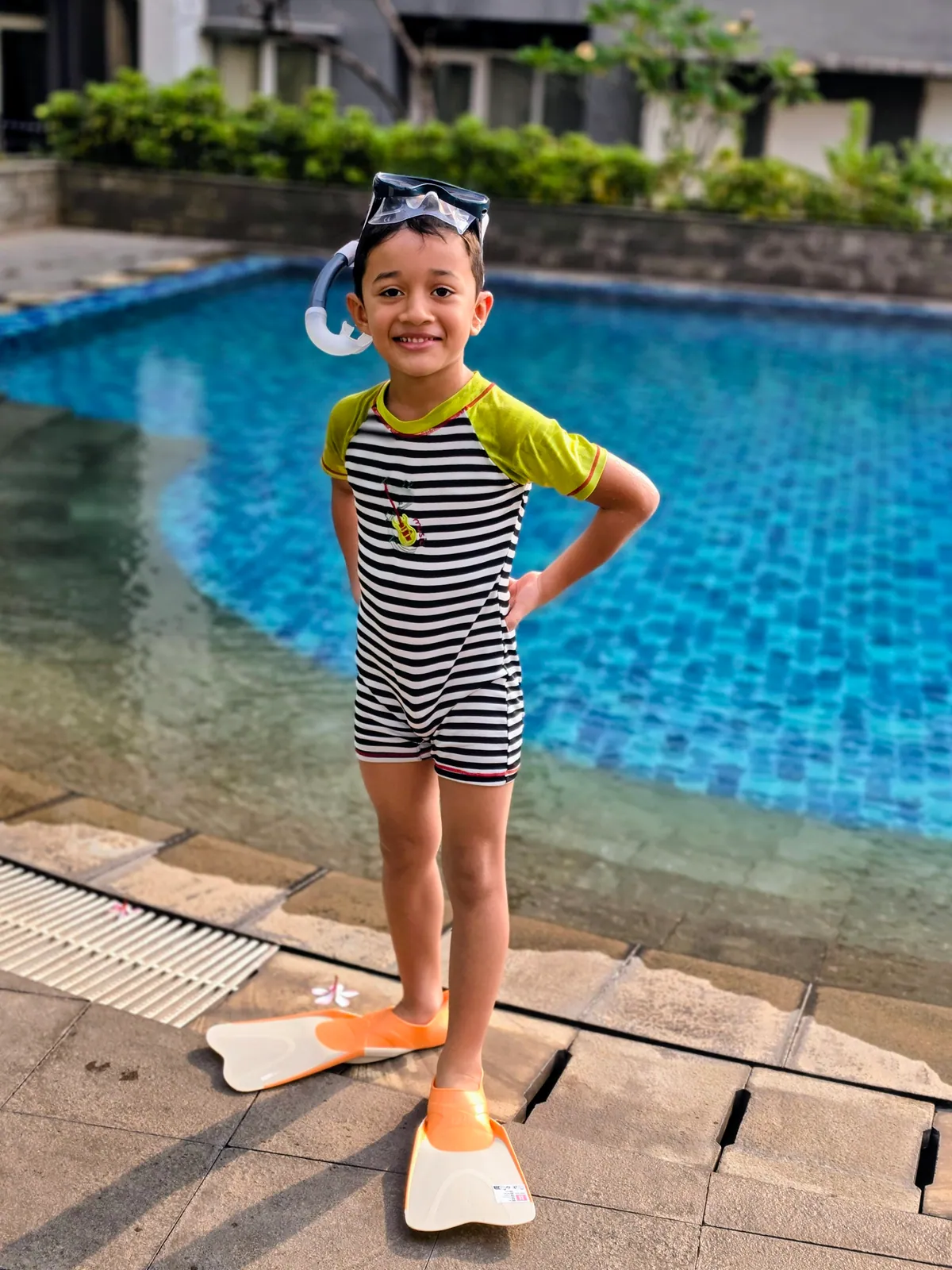 A young learner in a swimsuit and snorkel mask, ready to swim