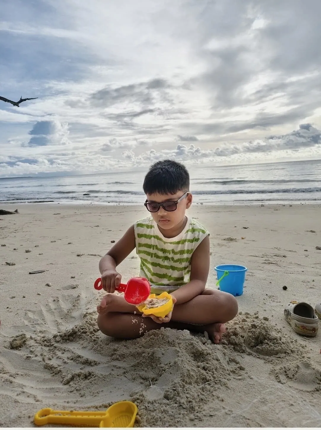 A young learner building a sandcastle on the beach