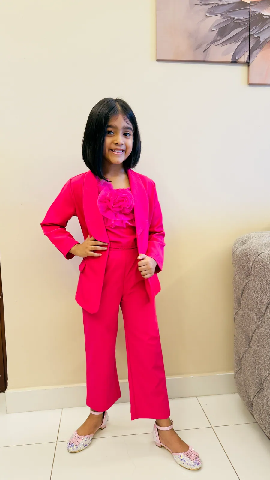 A young learner in a pink suit, hands on hips, ready for the day