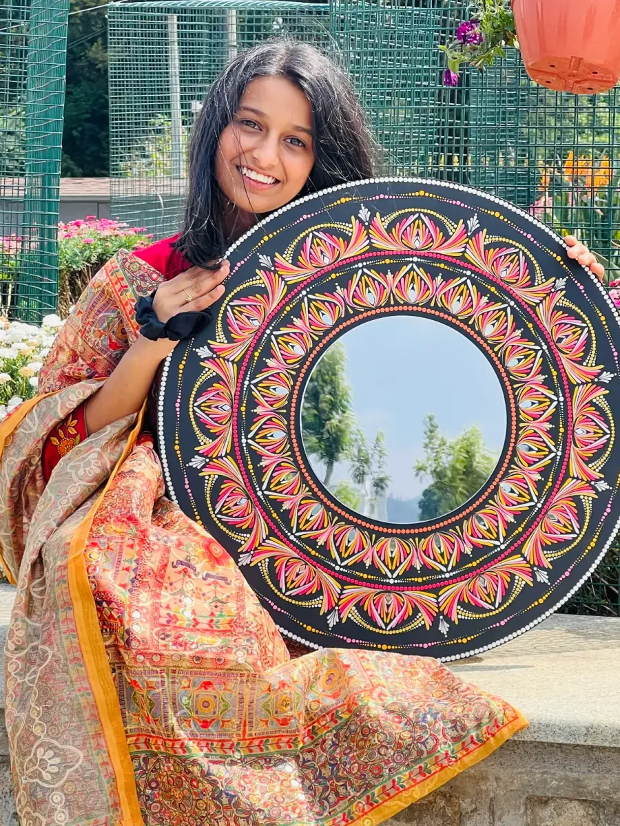 A learner holding up the large mandala she painted
