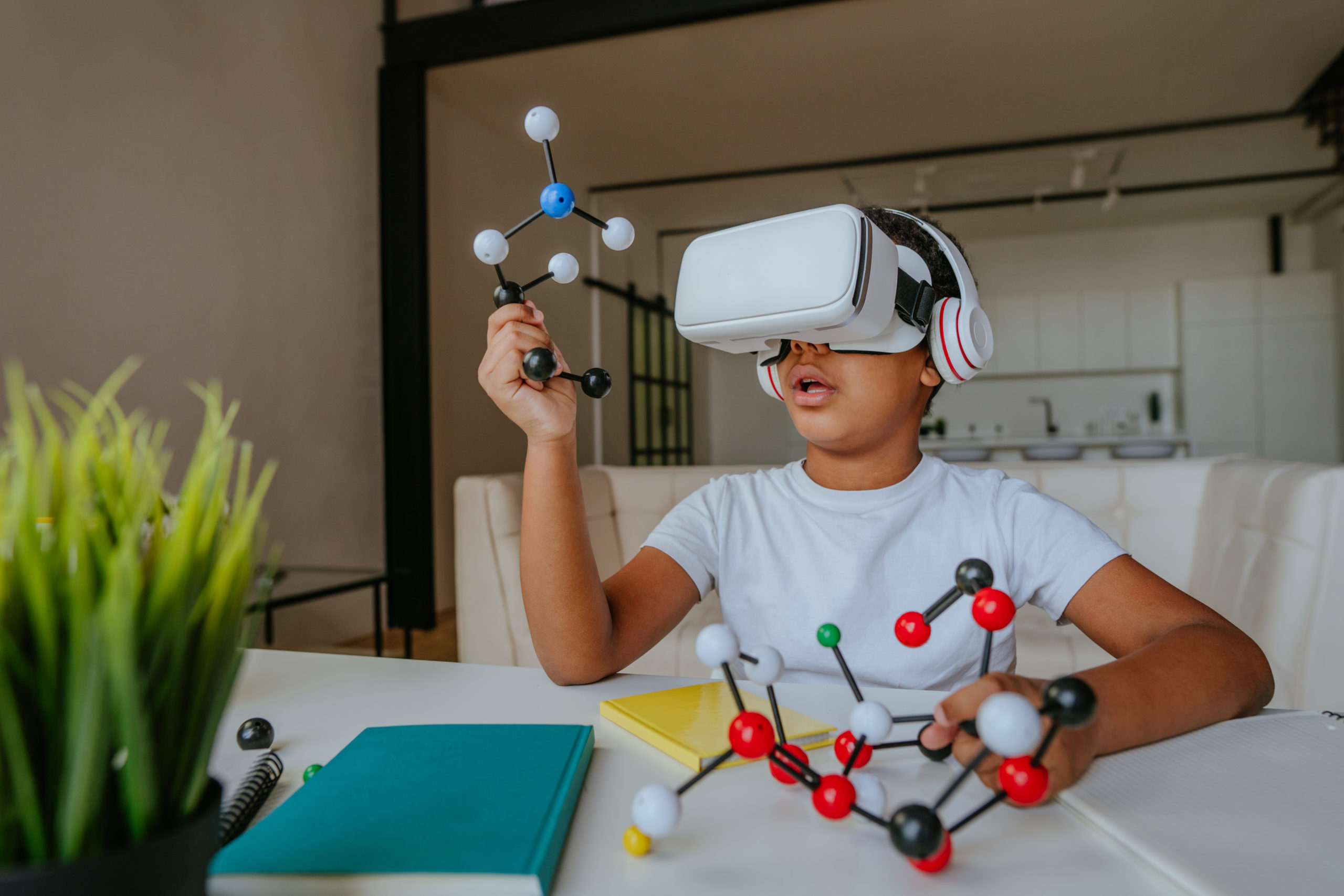 Boy using VR glasses holding molecular model